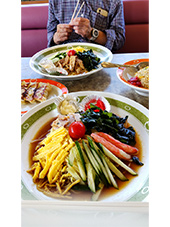 冷麺　奥にオジサンとチャーハンが写っている写真